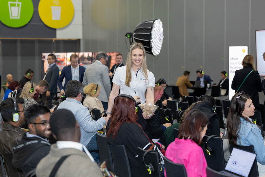 SmallBiz Melbourne attendees in a session room with headsets and event staff