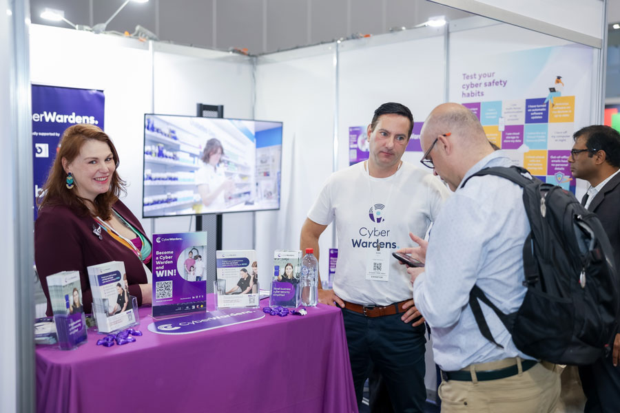 SmallBiz Melbourne exhibitors discussing cybersecurity services with an attendee